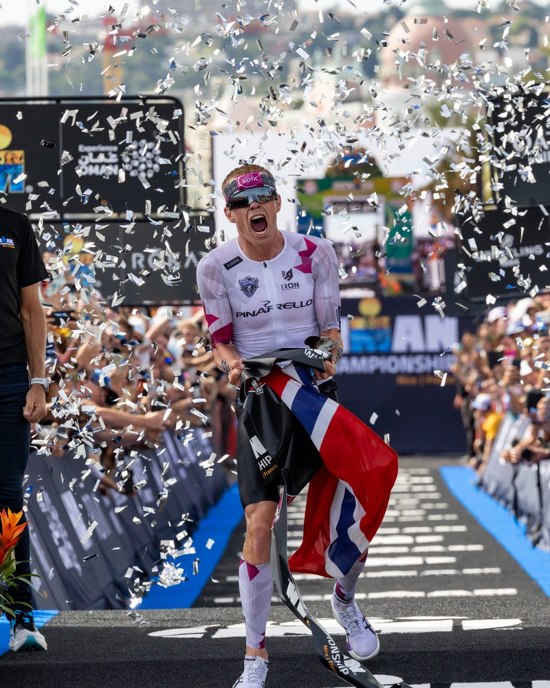 Triathlete celebrating at the finish line wearing OMIUS