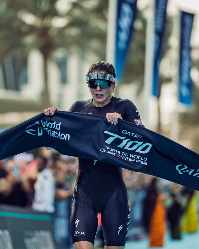 Triathlete crossing the finish line wearing an OMIUS cooling headband